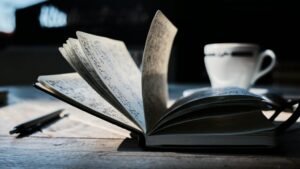 An open book and cup on a table